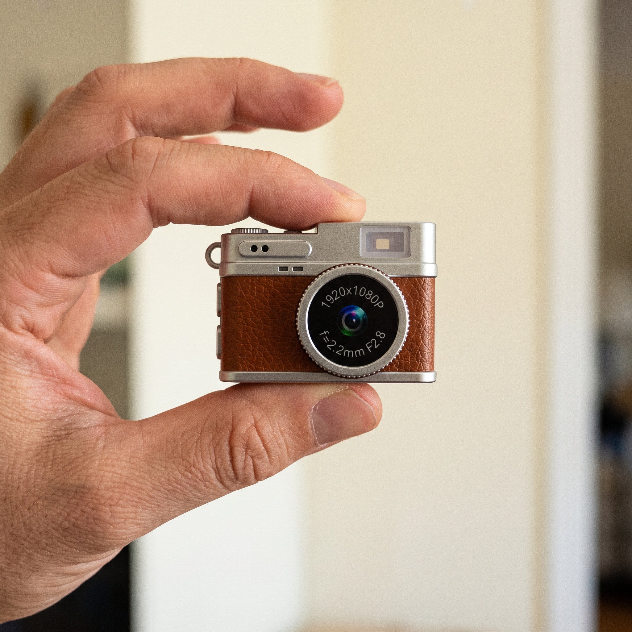 Tiny Brown Little Snap camera held in one hand