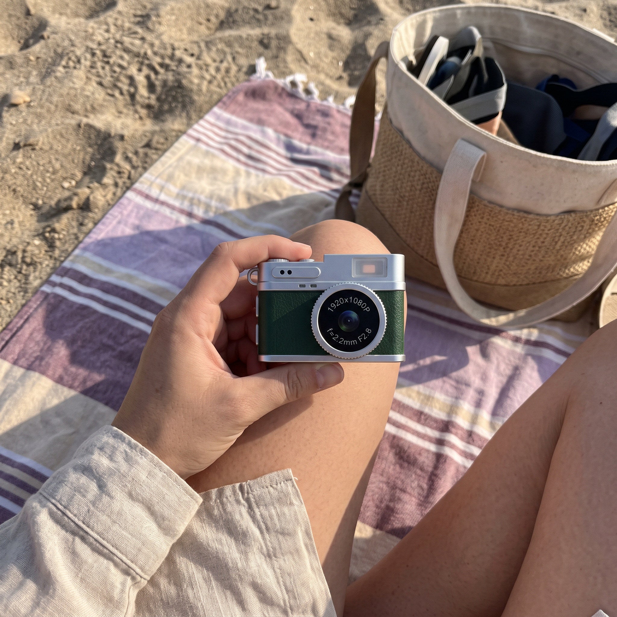 Owner holds a Green Little Snap camera by the beach