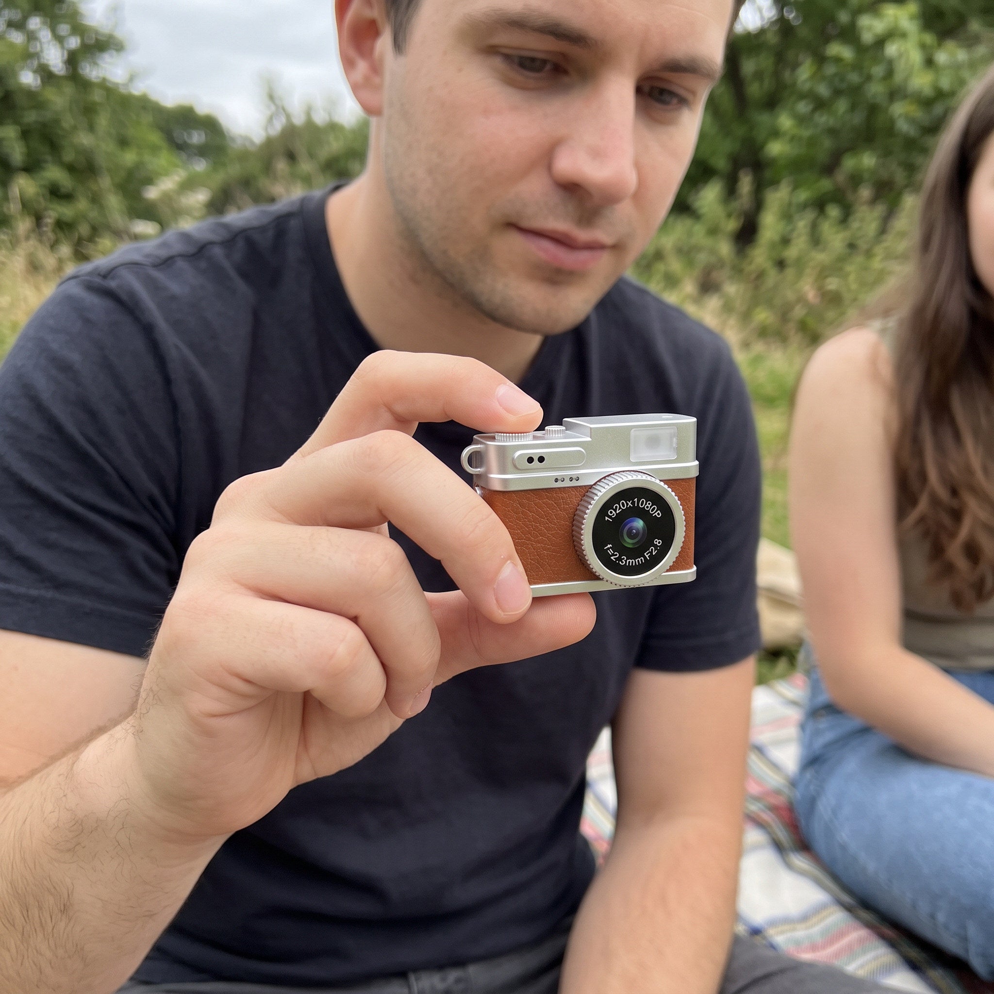 Man using a Little Snap camera at a picnic